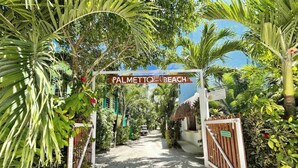 A pathway leading to a beach area with a sign reading "Palmetto Beach".