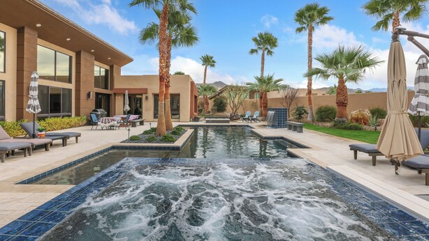 A pool area with a hot tub, lounge chairs, and palm trees. - Luxury Palm Springs Retreat. Pool, Spa & Stunning Mountain Views (Palm Springs)
