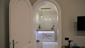 Vista del interior de un vestíbulo de hotel con mostrador de recepción, zona de estar y estación de café.