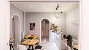 Una cocina moderna con encimera de madera, sillas blancas y una mesa de comedor.