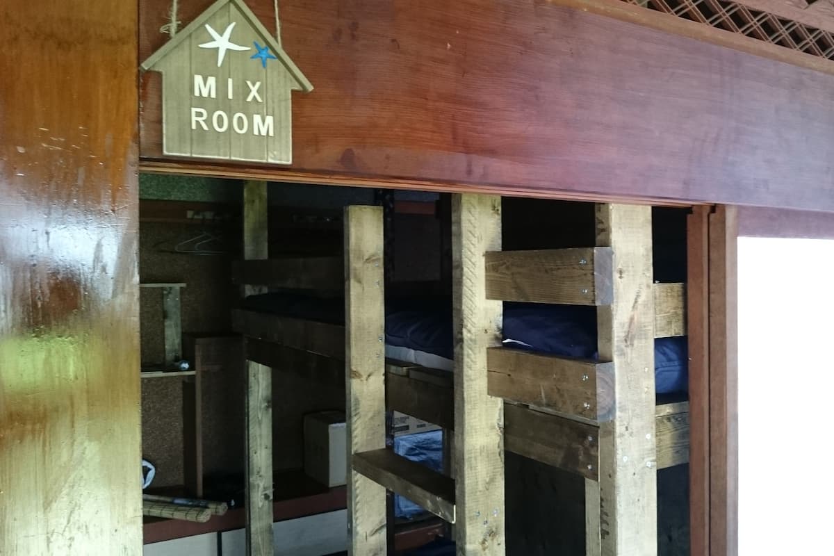 A wooden bunk bed room with a sign indicating a 'MIX ROOM'.