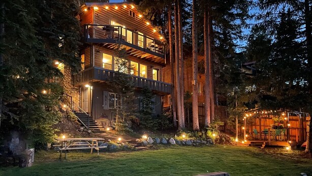 A multi-level log cabin with a stone staircase, surrounded by a well-maintained lawn and tall trees. - Quintessential Lake House on the shore of GL,  awe-inspiring views (Grand Lake)