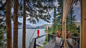 A deck with outdoor seating and a view of a lake and mountains. - Quintessential Lake House on the shore of GL,  awe-inspiring views (Grand Lake)