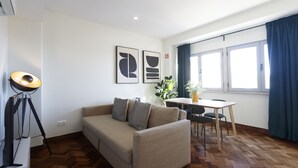 Ein modernes Wohnzimmer mit einer Couch, einem Esstisch und einer Lampe.