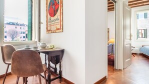 A dining area with a table, chairs, and a framed picture on the wall. - 7 WINDOWS ON VENICE APARTMENT (Venezia)