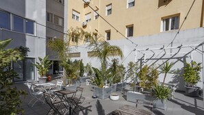 An outdoor patio area with seating and potted plants. - Negroni Balcony in Lisbon - by Misha's Place (1A) (Lisboa ciudad)