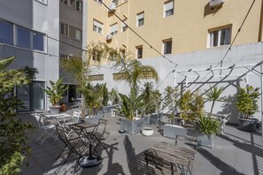 Un espace extérieur aménagé en terrasse, avec des sièges et des plantes en pot.