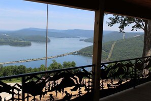 Enjoy breathtaking views of the serene water and lush surroundings from this balcony.