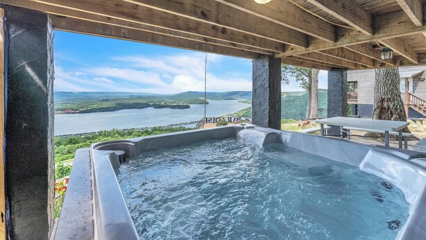 A hot tub with a view of a lake and mountains. - Rivers Ledge Cabin with breathtaking views, hot tub, & indoor pool! (Bryant)