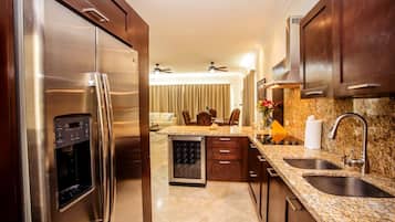 A modern kitchen with stainless steel appliances, granite countertops, and wooden cabinets.