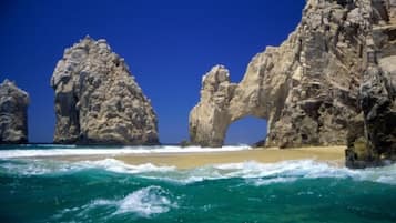 A coastal scene with large rock formations and a clear blue sky.