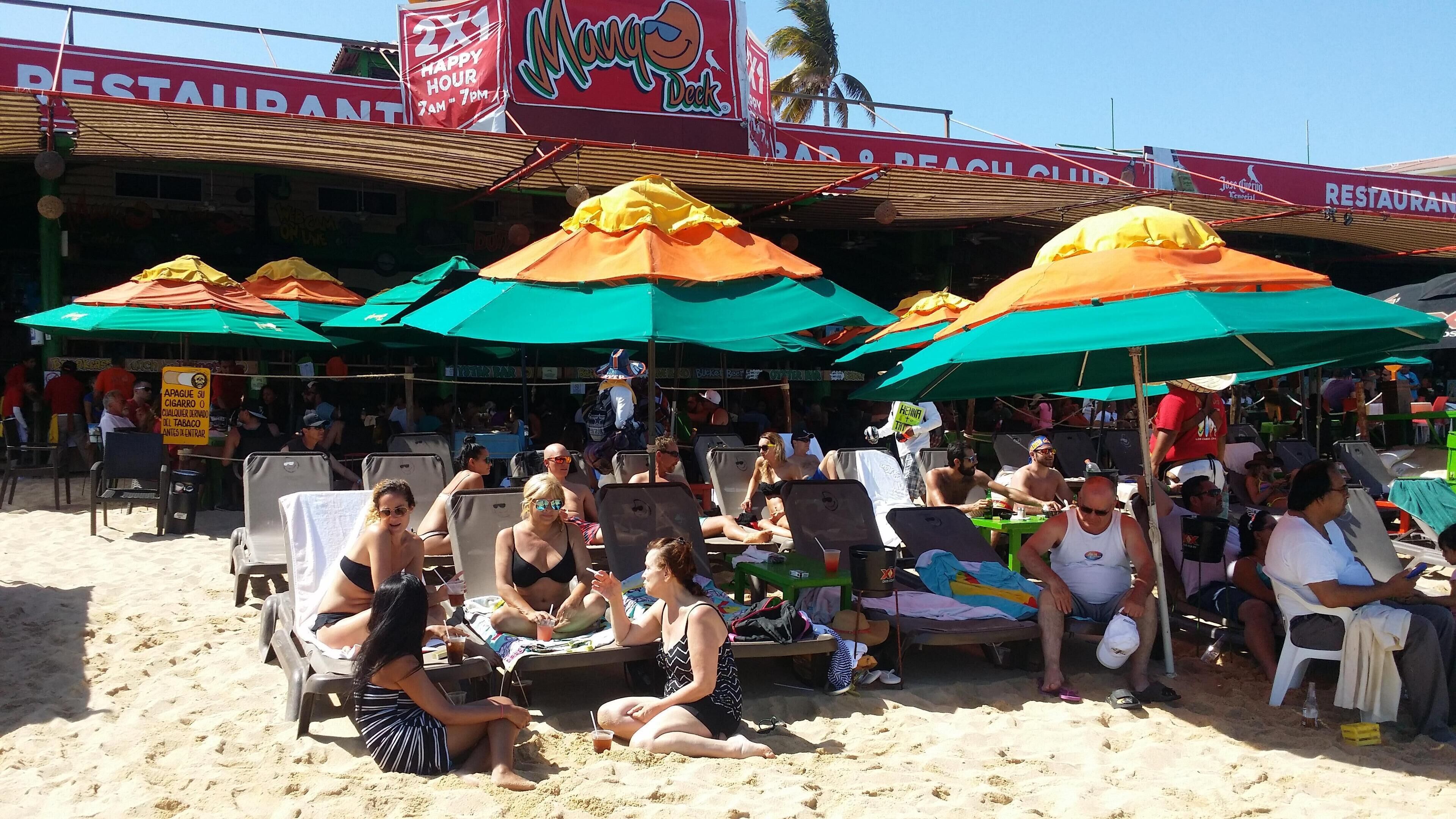 Un restaurant situé en bord de mer, avec une terrasse et des parasols.