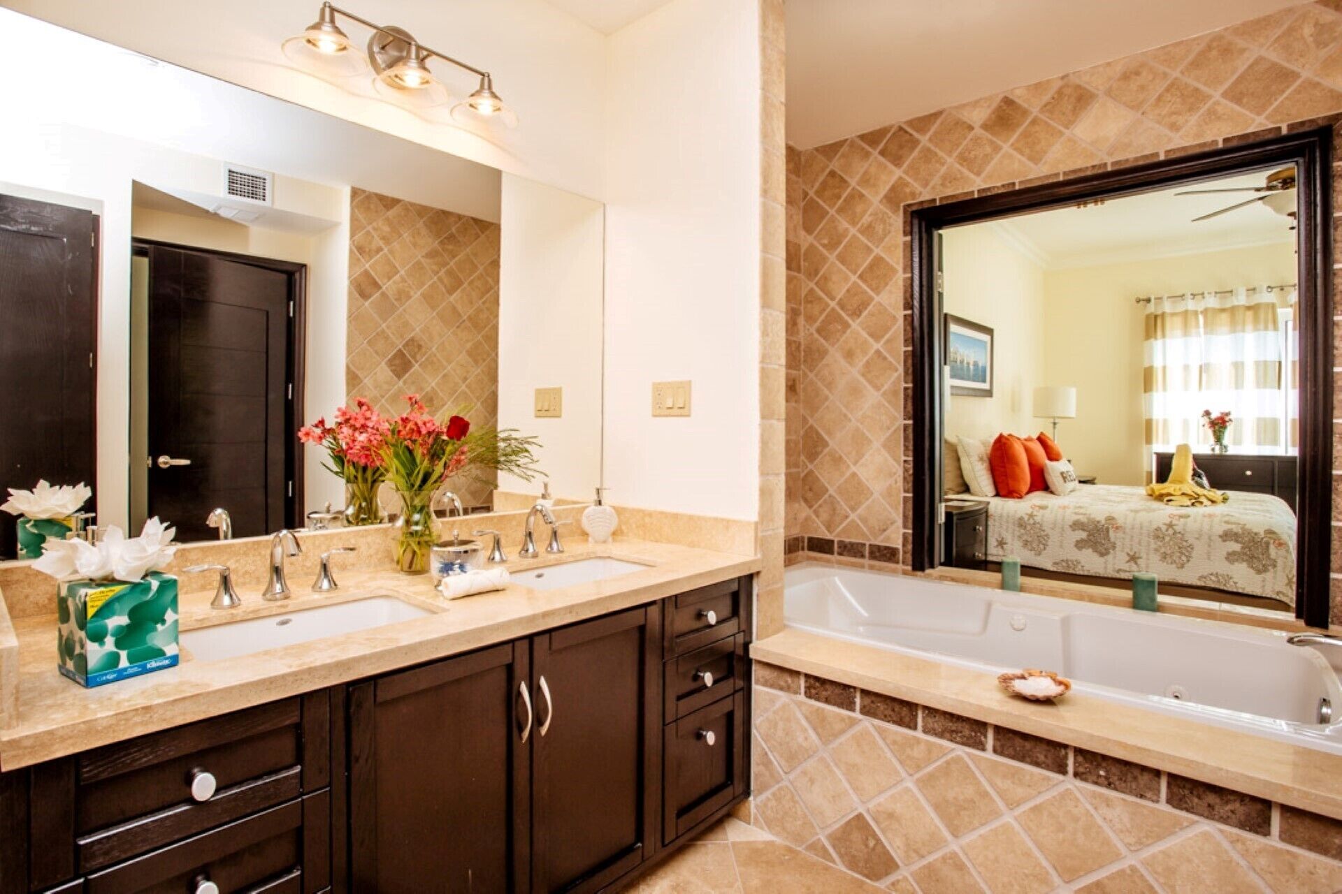A bathroom with a double sink vanity, a large mirror, and a bathtub.