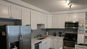 A modern kitchen with white cabinets, stainless steel appliances, a built-in oven, and a microwave. - DOWNTOWN NEWPORT HOTSPOT! Private Parking included - Open floor plan, spacious! (Newport)