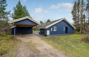 Kaksikerroksinen rakennus, jossa on katettu sisäänkäynti ja pieni ikkuna.