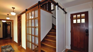 Una scala in legno con una porta in vetro che dà su un pianerottolo.