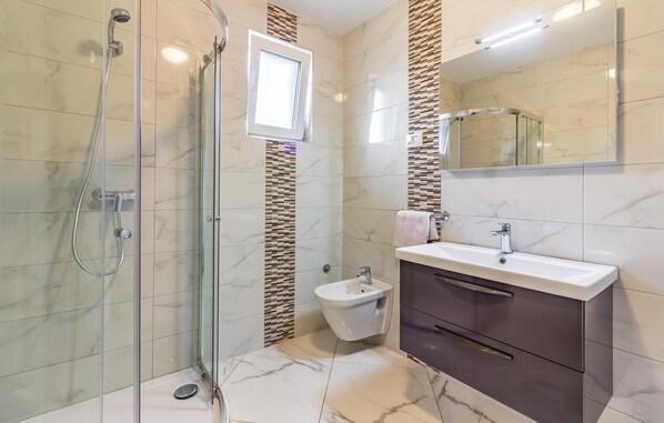 A modern bathroom with a glass-enclosed shower, a bidet, and a vanity with a mirror. - Stunning apartment in Medulin with WiFi (Medulin)