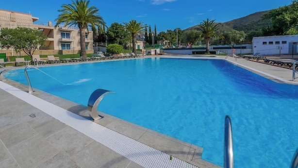 A rectangular swimming pool with a clear blue water surface, surrounded by a tiled deck. - Agi Rescator 325 Apartamento for rent in Roses Girona. (Rosas / Roses)