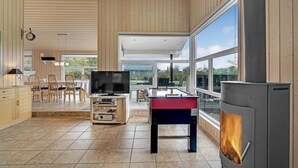 A spacious living area with a fireplace, a television, and a foosball table. - Awesome home in Hovborg with sauna (Hovborg)