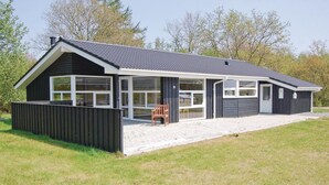 A modern two-story house with large windows, a covered porch, and a fenced yard. - Awesome home in Hovborg with sauna (Hovborg)