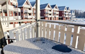 Ein Balkon mit Blick auf eine Reihe von roten und weißen Gebäuden mit mehreren Balkonen.