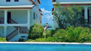 Un resort de dos pisos con una piscina en primer plano.
