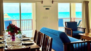 Un comedor con vista al océano, un sofá azul y una mesa para dos.