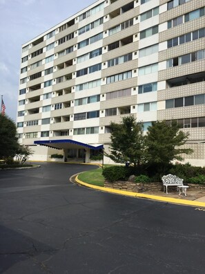 Un immeuble à plusieurs étages, doté d’une façade ornée, d’une entrée abritée et d’un parking.
