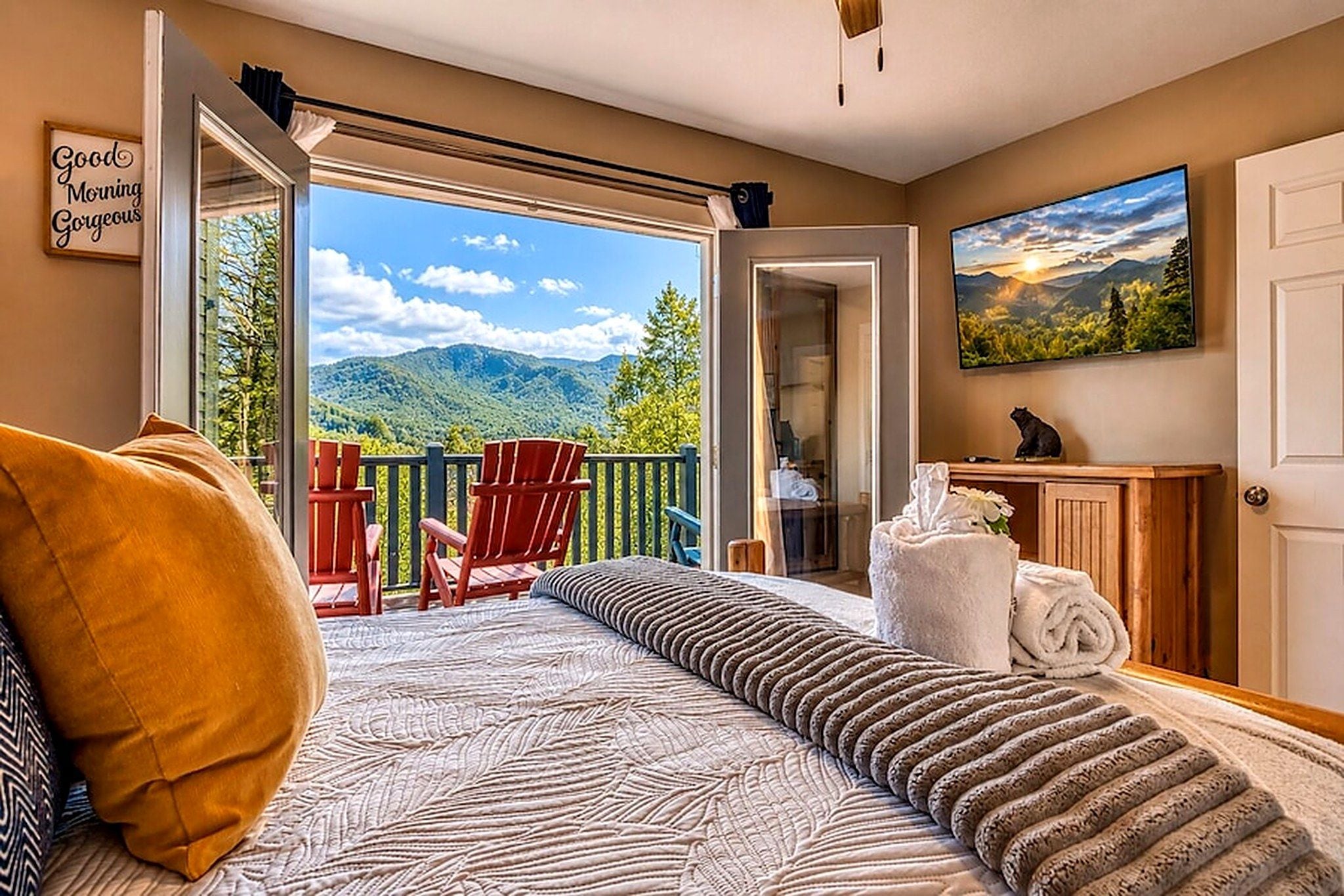 Une chambre à coucher avec un lit, une fenêtre, un balcon avec des chaises et un tableau.