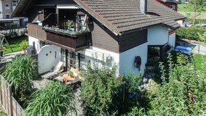 A two-story house with a balcony, a garden, and a visible garage. - Beautiful home in Mondsee with house a mountain view (Mondsee)