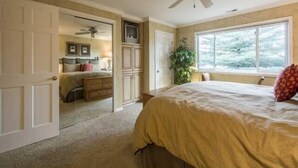 A bedroom with a bed, a ceiling fan, a window, and a door leading to another room. - Luxury Condo; Just steps to PCMR & Historic Main St!! (Park City)