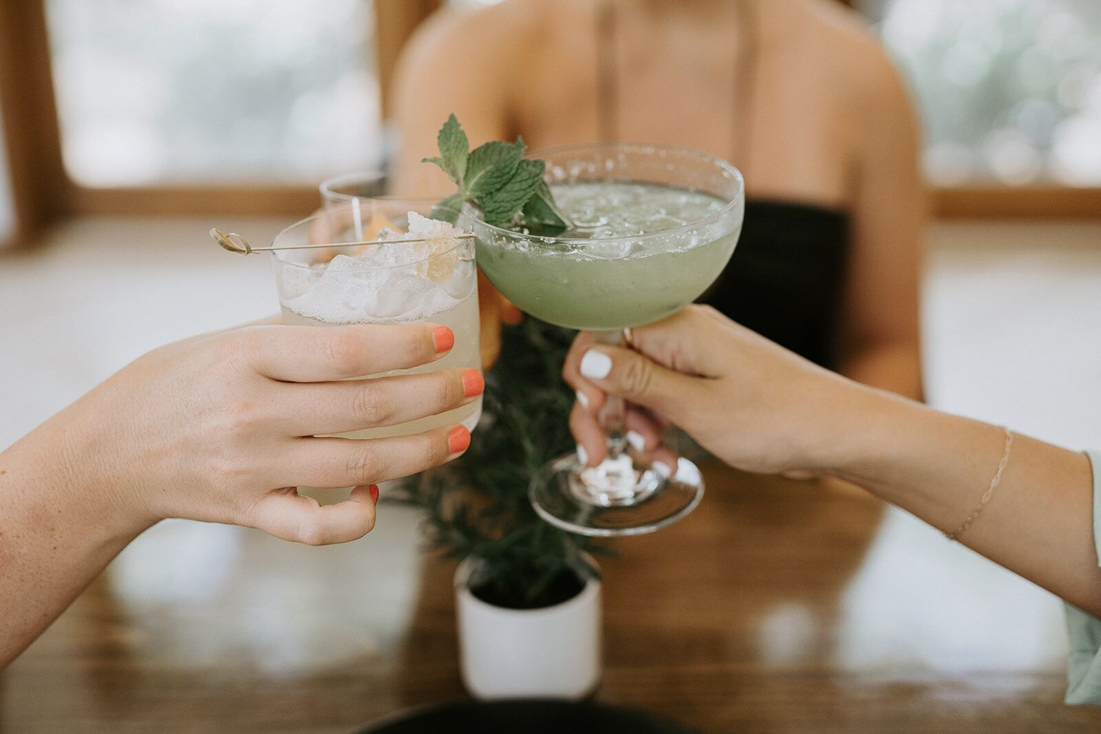Deux personnes tenant des verres à cocktails, avec de la glace et des décorations.