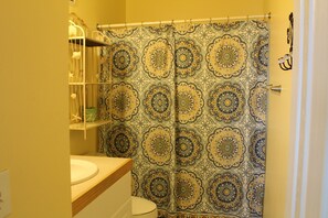 A bathroom with a patterned shower curtain, a white sink, and a toilet. - Relax and unwind - Tranquility and secure WIFI included for free! (Hilton Head Island)