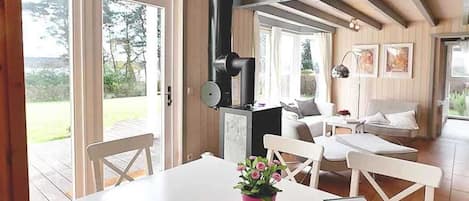 A cozy room with a white table, a red flower pot, and a book titled "Gastebuch".