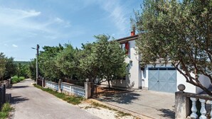 A residential street with a white house, a paved road, and a metal fence. - 2 bedroom stunning apartment in Krusevo (Krusevo)