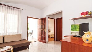A modern living room with a sofa, a TV, and a bookshelf. - 2 bedroom stunning apartment in Krusevo (Krusevo)