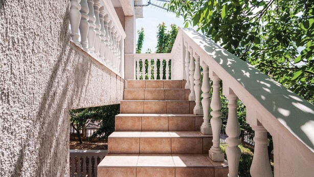 A staircase with white balustrades and beige steps leading up to a balcony. - 2 bedroom stunning apartment in Krusevo (Krusevo)