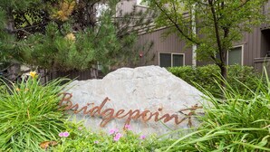 Un grand rocher sur lequel est gravé le mot « Bridgepoint », entouré de verdure et d’arbres.