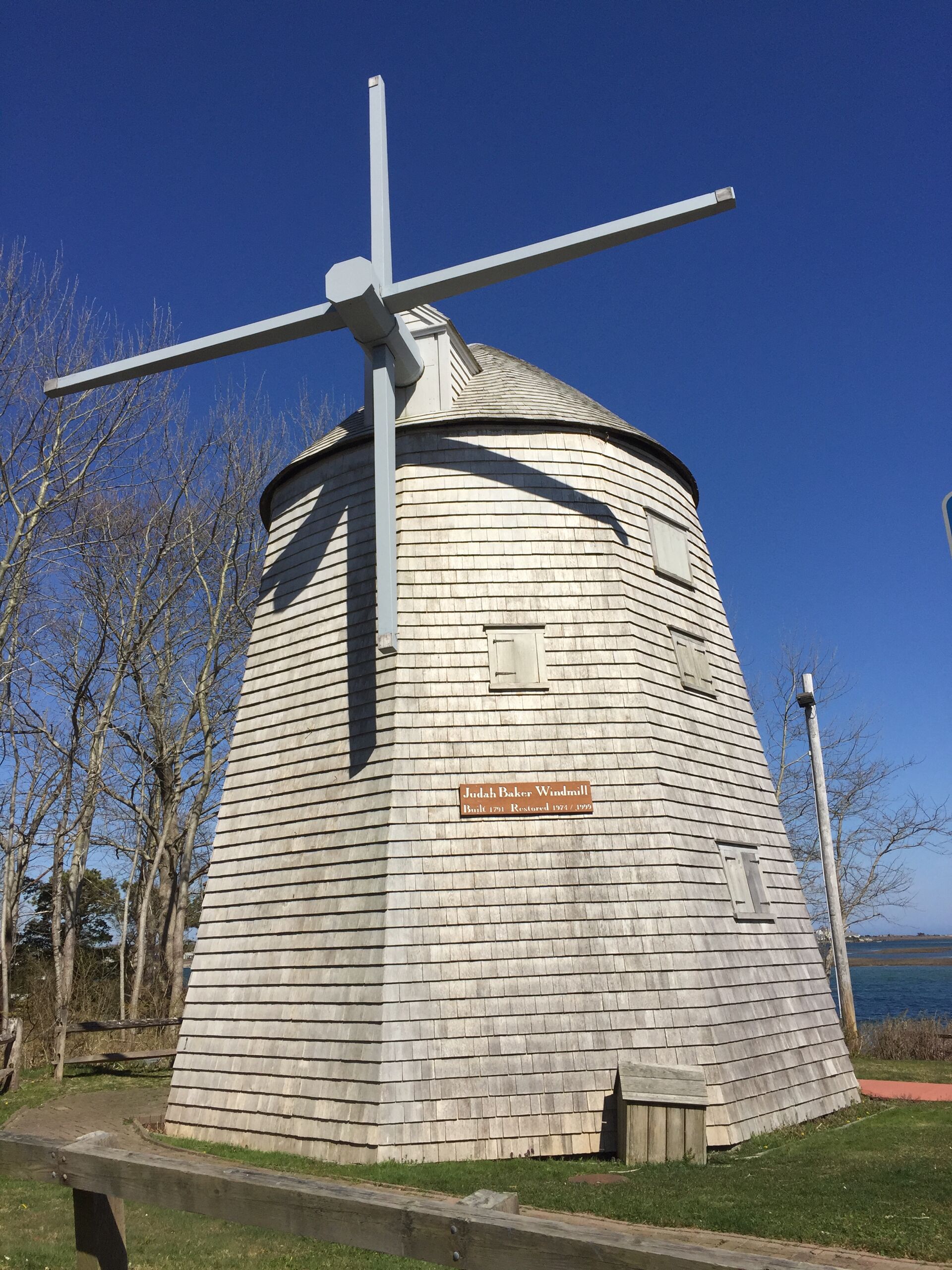 Un moulin à vent historique, doté d’une structure en bois et d’une plaque indiquant qu’il a été construit en 1791 et restauré en 1971.