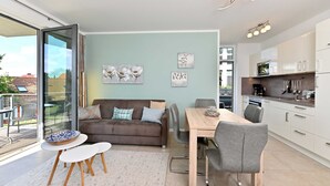 Un espacio habitable moderno con comedor, sofá y cocina.