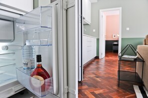 A modern kitchen with white cabinets and a wooden floor.