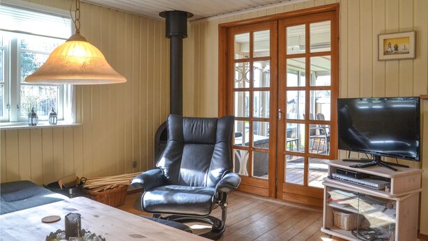 Ein gemütliches Wohnzimmer mit Ledersessel, Fernseher und Holztisch.