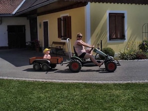 A person riding a tricycle with a trailer on a paved road.