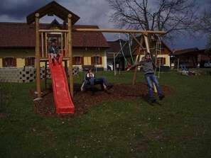 Un'area giochi con uno scivolo e altalene.