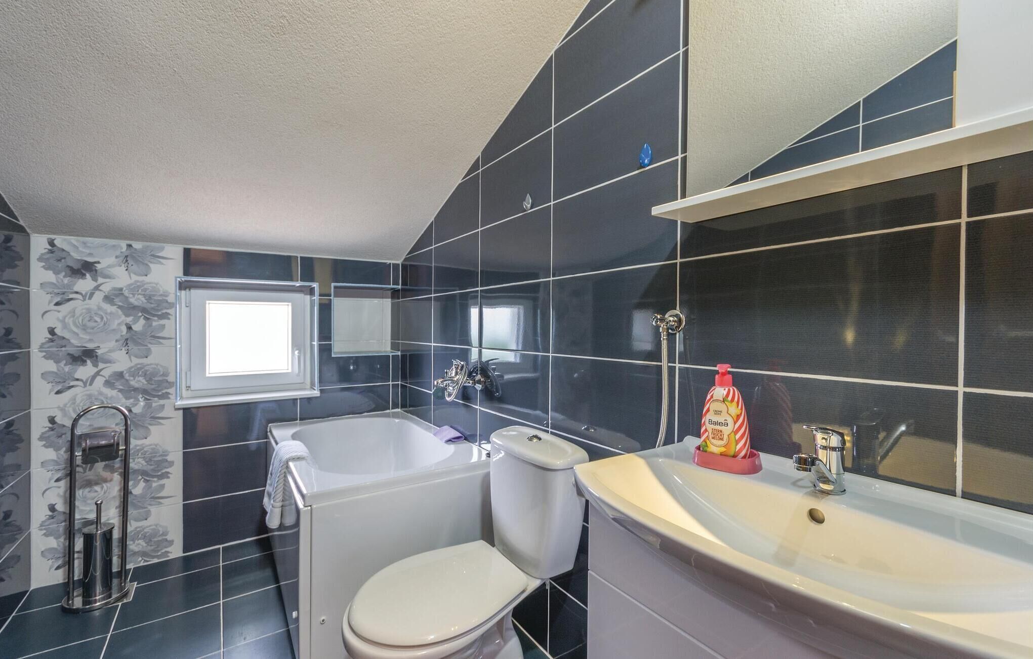 A bathroom with a toilet, a bathtub, and a sink.