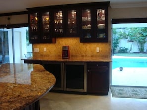 Enjoy cooking in this well-equipped kitchen with a coffee maker and ample kitchenware, adjacent to a pool.