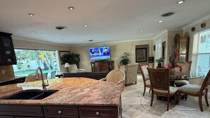 A spacious kitchen with a granite countertop, dark cabinetry, and a built-in sink. - Island Living, Within Walking Distance To Beach Restaraunts Shops Parks Marina (Vero Beach)