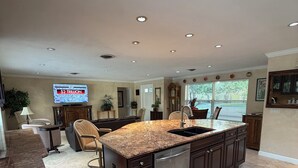A modern kitchen with granite countertops, stainless steel appliances, and dark cabinetry. - Island Living, Within Walking Distance To Beach Restaraunts Shops Parks Marina (Vero Beach)