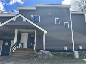 Wood stairs lead up to a sheltered entrance porch. - Renovated Townhouse at Peaceful Suntec, Shuttle to Mount Snow. Hot Tub! (West Dover)