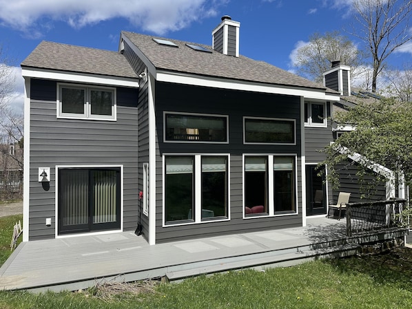 New gray siding townhouse exterior with white trim, large windows, skylights, and a spacious light-gray deck. - Renovated Townhouse at Peaceful Suntec, Shuttle to Mount Snow. Hot Tub! (West Dover)